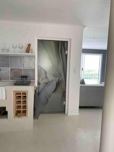 a living room with a bed in a room at TAKE TWO lovely beach apartment, Great Brak River in Groot Brak Rivier