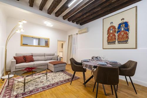 ein Wohnzimmer mit einem Tisch und einem Sofa in der Unterkunft Ca Maurice - San Marco Canal view in Venedig