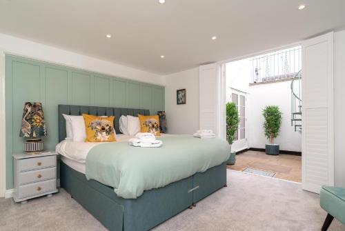 a bedroom with a large bed with orange pillows at Stunning 2 Bed in the Heart of Cheltenham! in Cheltenham