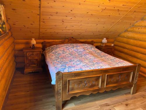 a bedroom with a bed in a log cabin at У Фёдера и Маргариты in Nizhnyaya Grabovnitsa
