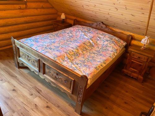 a bedroom with a bed in a cabin at У Фёдера и Маргариты in Nizhnyaya Grabovnitsa