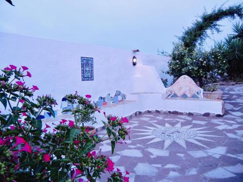 un jardín con flores y un patio de piedra en Alba B&B en Carloforte