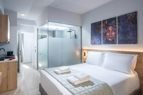 um quarto com uma grande cama branca e um chuveiro em Nuovo Crete By Sea em Amoudara Herakliou