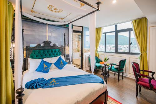 a bedroom with a bed with blue pillows at Athena Hotel Quy Nhơn in Quy Nhon