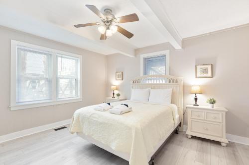 a white bedroom with a bed and a ceiling fan at 118 E ARCTIC UNIT B SALTY SHACK ACROSS THE ST FROM BEACH in Folly Beach