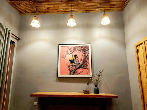 a painting of a bird on a wall with lights at Mộc Châu Peachy Garden in An Pon