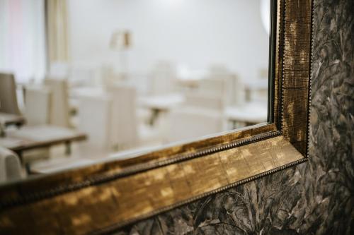an old mirror on a wall in a classroom at Elixír Medical Wellness Hotel in Mórahalom