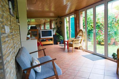 a screened in porch with chairs and a television at Casa Triana in Soure