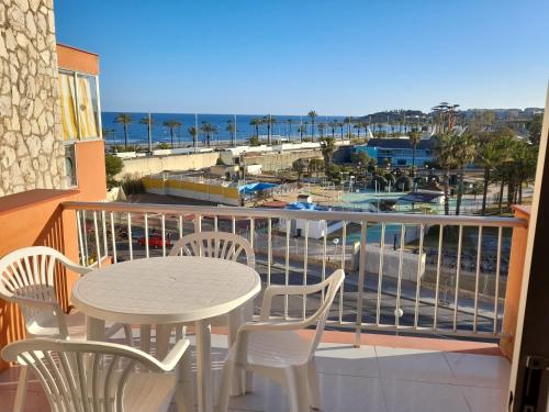 een balkon met een tafel en stoelen en uitzicht op de oceaan bij Apartamento Palmeras in La Pineda