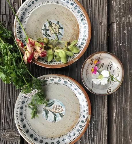 a group of plates sitting on a wooden table at Travelers House おーさんてぃん青空舎 in Taketomi