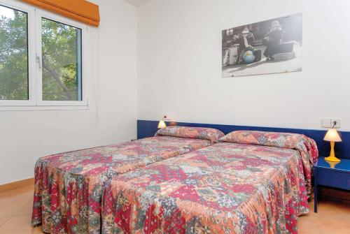 ソン・ボウにあるCan S'Olivaのベッドルーム1室(カラフルなベッドカバー、窓付)