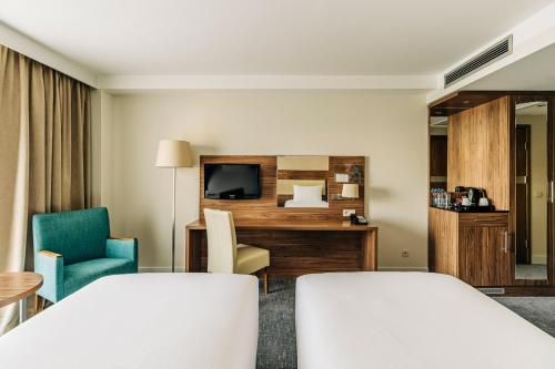 a hotel room with a bed and a tv at Holiday Inn Łódź by IHG in Łódź