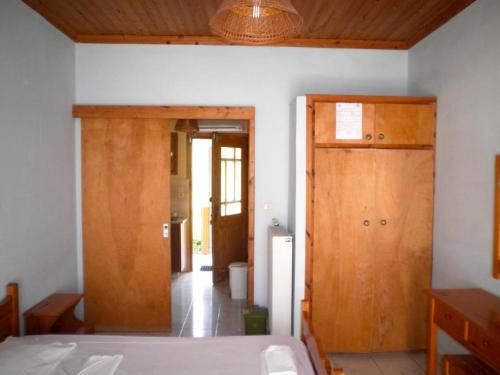 a bedroom with a bed and a wooden door at Kostas Studios in Vasiliki