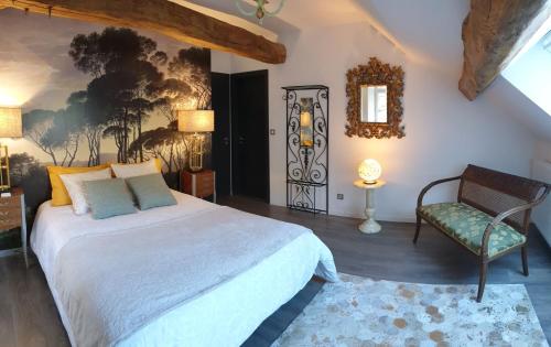 um quarto com uma cama grande e uma cadeira em Maison Bélénos em Nevy-sur-Seille