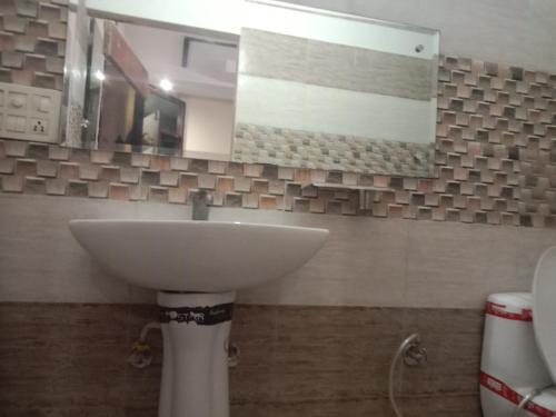 uma casa de banho com um lavatório e um espelho em City Palace em Panchkula