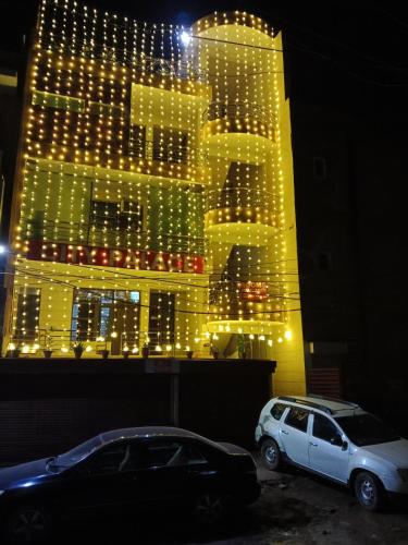 two cars parked in front of a building with lights at City Palace in Panchkula