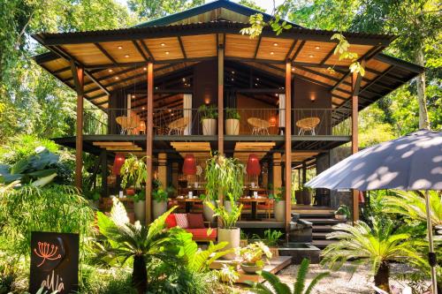 uma casa com um pavilhão num jardim com plantas em aWà Beach Hotel em Puerto Viejo