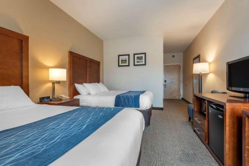 a hotel room with two beds and a flat screen tv at Comfort Inn Apalachin - Binghamton W Route 17 in Apalachin
