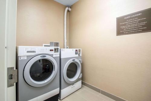 a laundry room with a washing machine and a sign at Comfort Inn Apalachin - Binghamton W Route 17 in Apalachin