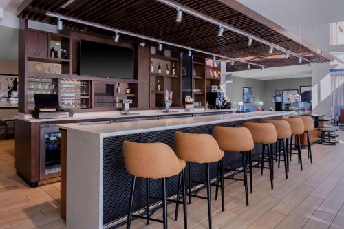 a bar with a row of stools in a restaurant at Hyatt Place Charlotte University in Charlotte