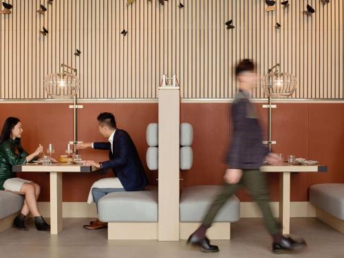 a man and woman sitting at a table in a restaurant at EAST Hong Kong in Hong Kong