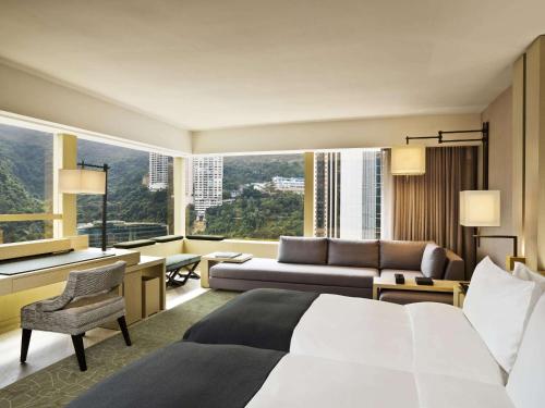 una camera d'albergo con letto e soggiorno di The Upper House a Hong Kong