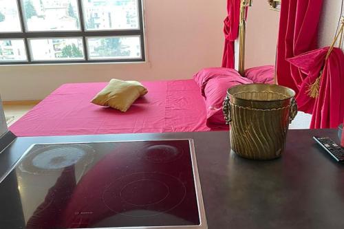 una camera con letto rosa e tavolo con computer portatile di Appartamento vista lago con piscina a Lugano