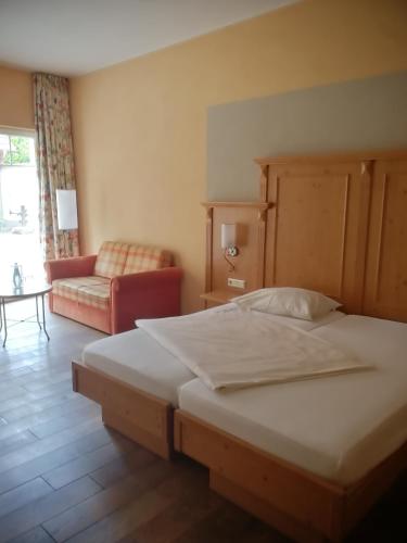 a bedroom with a large bed and a couch at Gästehaus Reßler in Harxheim