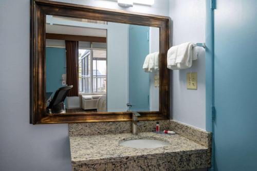 uma casa de banho com um lavatório e um espelho. em Days Inn by Wyndham Perrysburg Toledo em Perrysburg