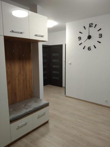 une pièce vide avec une horloge sur le mur dans l'établissement Apartament Berylowa 1, à Konin