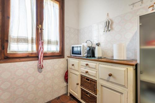 a kitchen with a microwave on a counter at Casa Nicoleup in Porto Columbu - Perdʼe Sali