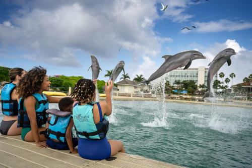 a group of children watching dolphins in the water at Moon Palace Jamaica - All Inclusive in Ocho Rios