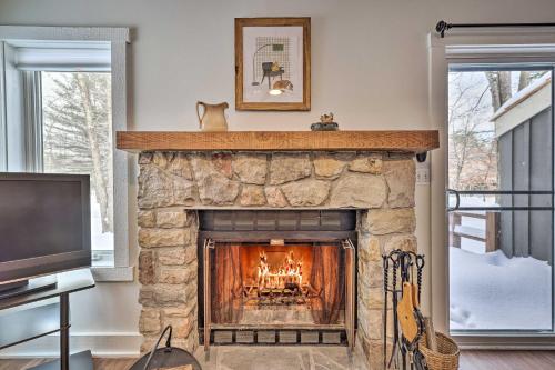 a living room with a stone fireplace and a tv at Lake Harmony Townhome Less Than 1 Mi to Jack Frost! in Lake Harmony