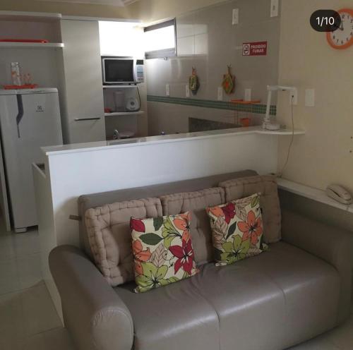a couch with two pillows sitting in a living room at Flat em Boa Viagem in Recife