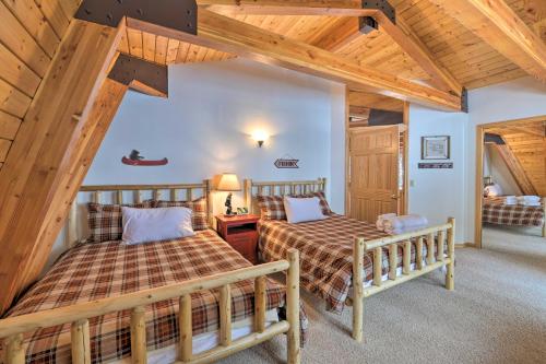 two beds in a room with wooden ceilings at Wild Huckleberry Alpine Cabin Fireplace and Deck! in Alpine