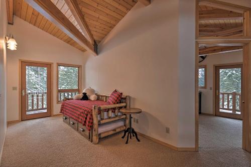 a person laying on a bed in a room with windows at Wild Huckleberry Alpine Cabin Fireplace and Deck! in Alpine
