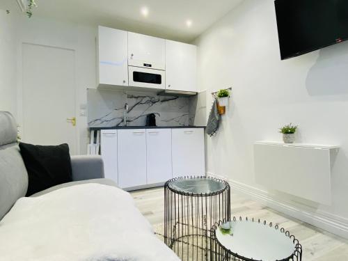 un salon avec un canapé et une cuisine dans l'établissement Le petit écrin de Deauville, à Deauville