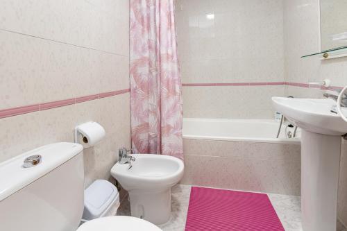 a bathroom with a white toilet and a sink at Studio Playa del Cura in Torrevieja
