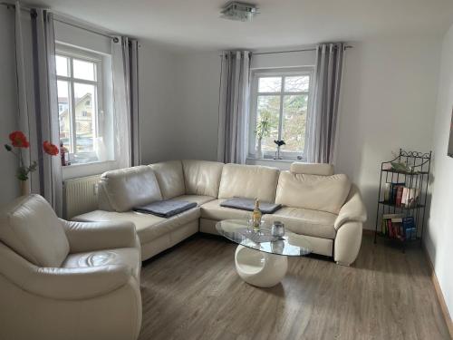a living room with a white couch and a table at Traumferienwohnung Ostseebad Baabe - Rügen in Baabe