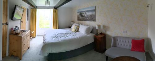 a bedroom with a large bed and a chair at The Burrows Bed and Breakfast in Pembroke