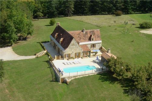 eine Luftansicht eines Hauses mit Pool in der Unterkunft Villa en pierre 10 pers, piscine chauffée in Saint-Amand-de-Coly