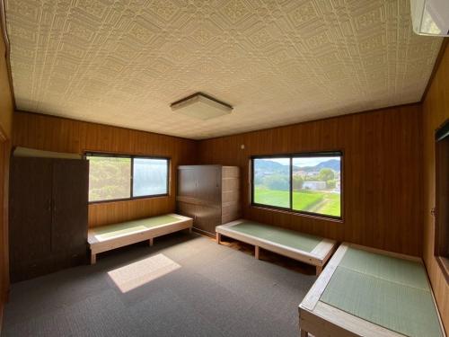 um quarto vazio com dois bancos e uma janela em Machiyado AETE - Vacation STAY 22032v em Sanuki