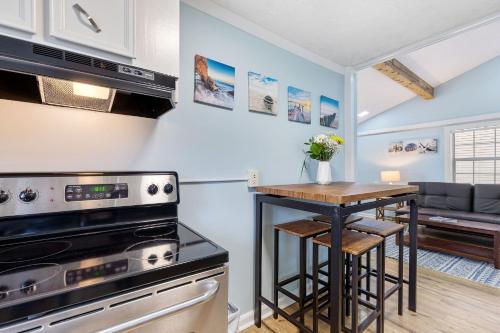 a kitchen with a stove and a table at 23 Center St - Sunny Side Up - Upstairs Apartment in Folly Beach