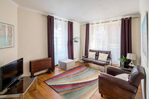 een woonkamer met een bank en een televisie bij Cosy 2 Bedroom Apartment in Bayswater in Londen