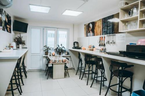 a kitchen with a bar with stools in it at Hostel CUBA in Minsk