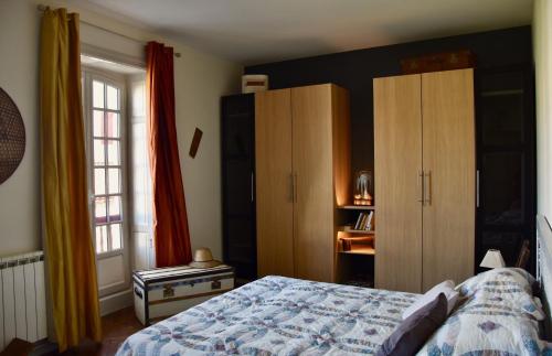 a bedroom with a bed and wooden cabinets at Appartement Erlandebaita Centre bourg 3 personnes in Urrugne