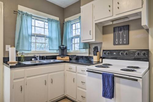 a kitchen with white cabinets and a white stove top oven at Chic and Cozy Greensboro Home, 2 Mi to Dtwn! in Greensboro