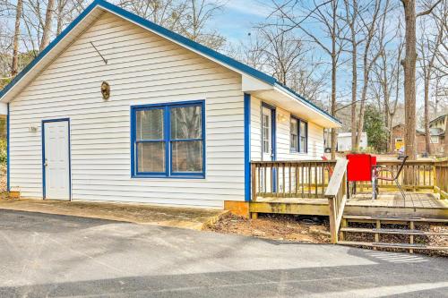 a small white house with a porch and a red chair at Lakefront Retreat with Private Docks and Gazebo! in Resseaus Crossroads