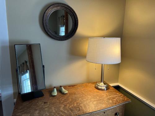 a lamp on a dresser next to a mirror at Shoreham Inn Bed & Breakfast in Shoreham
