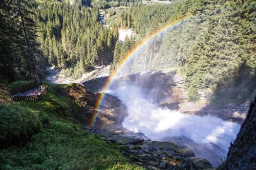 a rainbow over a river with a waterfall at Chalet in Krimml near Europe's Highest Waterfall in Krimml